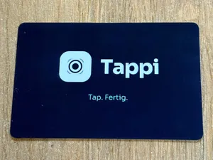 Tappi NFC-Karte aus PVC mit dem Aufdruck Tap. Fertig. auf einem Holztisch